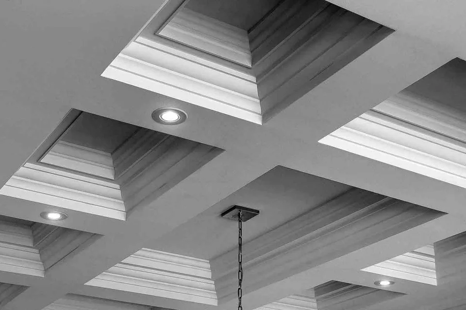 Coffered ceiling grid with layered mouldings and recessed downlights.