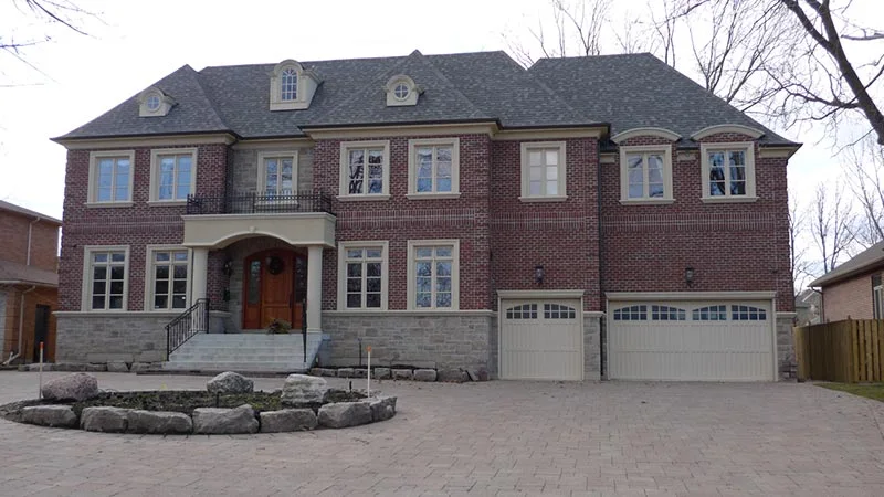 Brick house with pale trim framing its windows and central entrance.