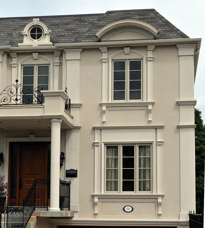 House exterior with pilasters, window surrounds and an arched doorway.