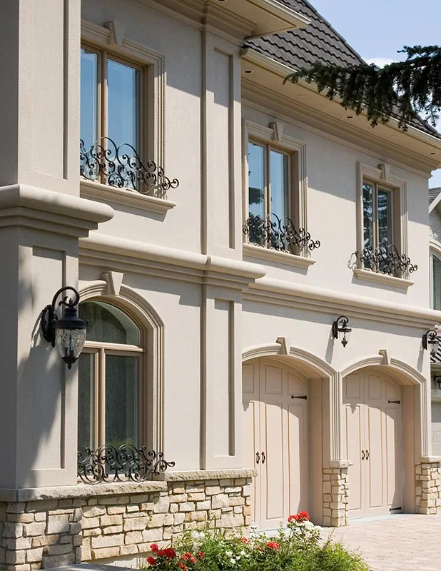 Window surrounds and decorative trim on a pale two-storey façade.
