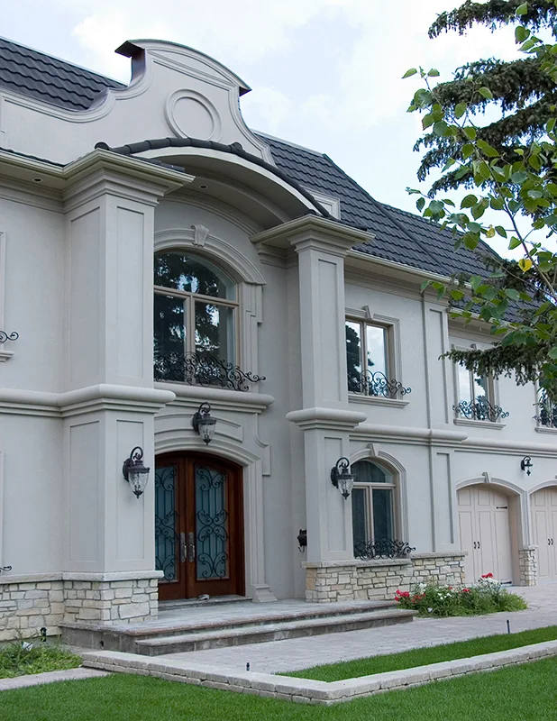 White house with decorative window surrounds and a curved central roofline.
