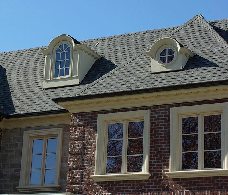 Brick façade with pale window surrounds and two roof dormers.