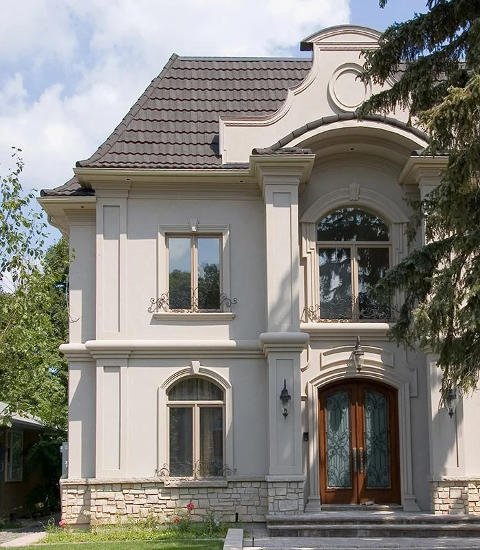 House entrance with tall windows, columns and curved roofline details.