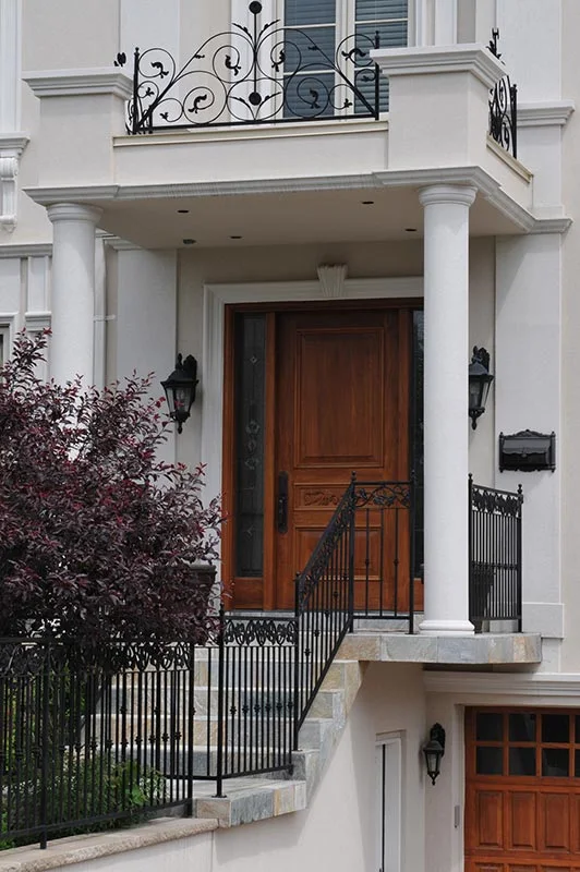 Columns framing a doorway below a balcony.