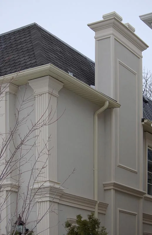 Rectangular pilaster rising beside a pale exterior wall.