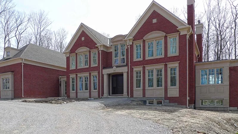 Red brick house with white window surrounds, corner trim and an arched entrance.